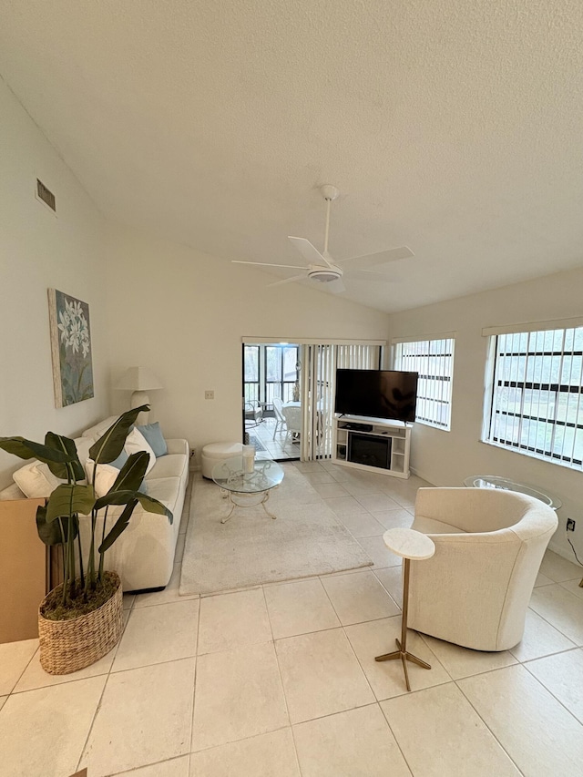 living room featuring lofted ceiling, light tile patterned floors, and plenty of natural light