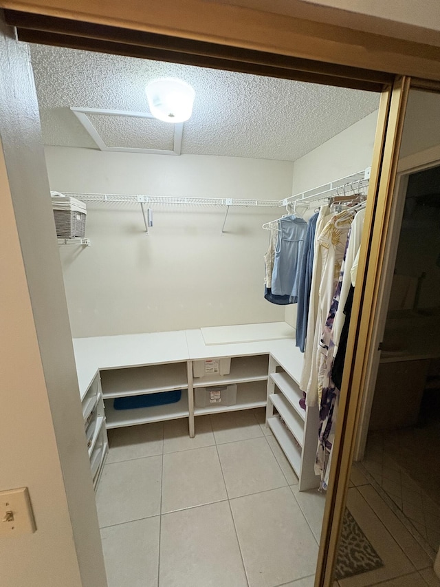 walk in closet with light tile patterned floors