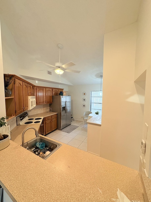 kitchen featuring ceiling fan, light tile patterned flooring, sink, range with electric cooktop, and stainless steel fridge