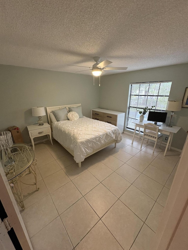 bedroom with ceiling fan, a textured ceiling, and light tile patterned floors