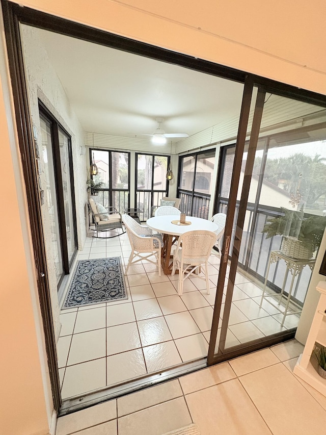 unfurnished sunroom with ceiling fan