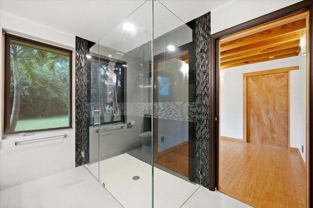 bathroom featuring tile patterned flooring, toilet, and walk in shower