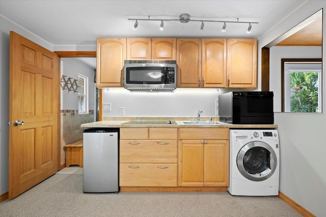 kitchen featuring sink, fridge, black electric stovetop, light brown cabinetry, and washer / dryer