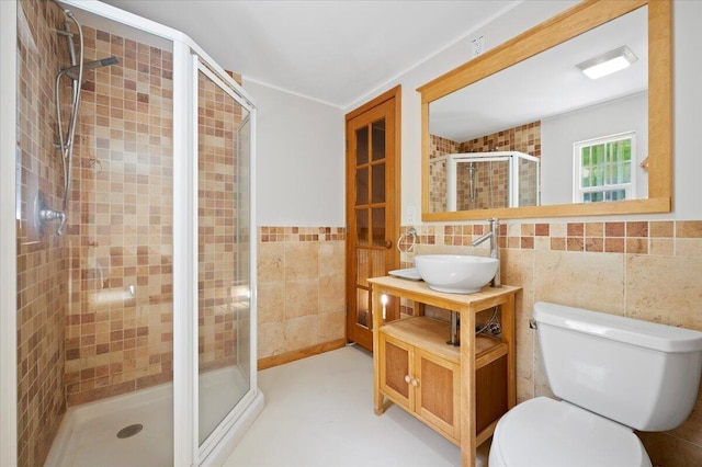 bathroom with tile walls, vanity, toilet, and walk in shower