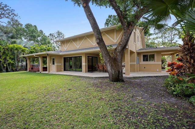 rear view of property featuring a patio area and a lawn