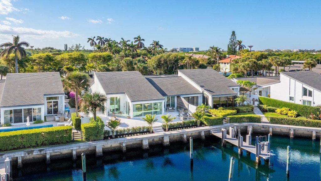 back of property with a patio and a water view