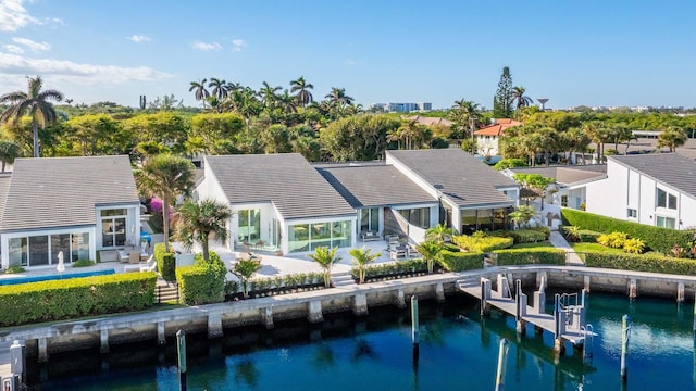 back of property with a patio and a water view