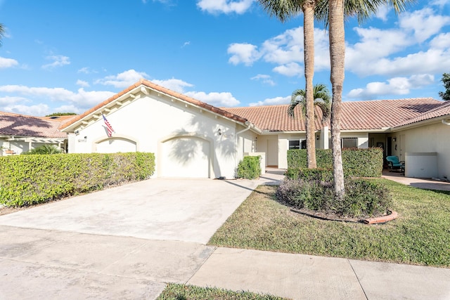 mediterranean / spanish-style home featuring a garage and a front lawn