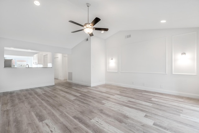 unfurnished living room with ceiling fan, lofted ceiling, and light wood-type flooring