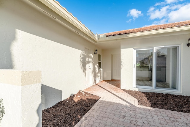 view of exterior entry with a patio