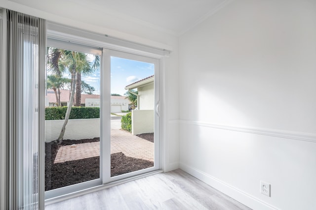 doorway to outside with crown molding and hardwood / wood-style flooring