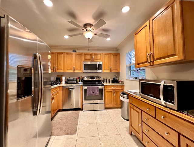 kitchen featuring ceiling fan, light tile patterned floors, appliances with stainless steel finishes, and ornamental molding