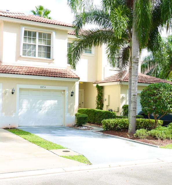 view of front of property with a garage, a tile roof, driveway, and stucco siding