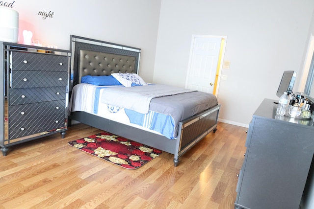 bedroom featuring baseboards and wood finished floors