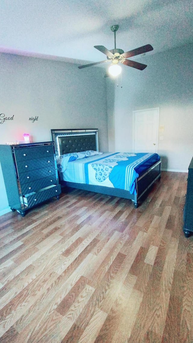 bedroom featuring light wood-style flooring, a ceiling fan, and a textured ceiling