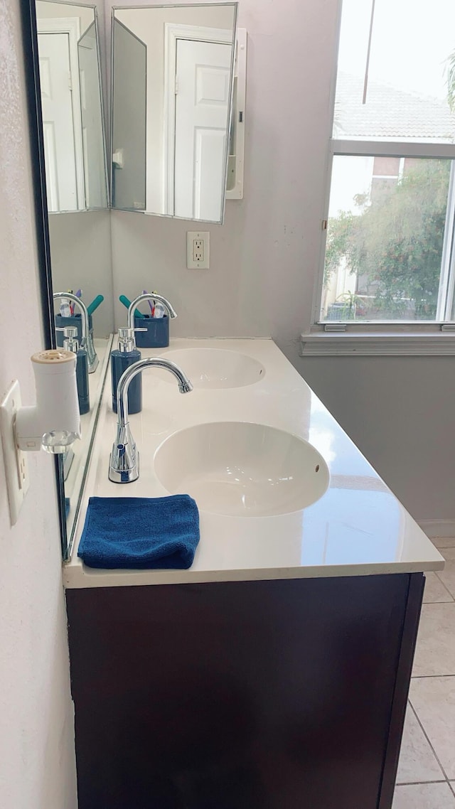 bathroom with double vanity, a sink, and tile patterned floors