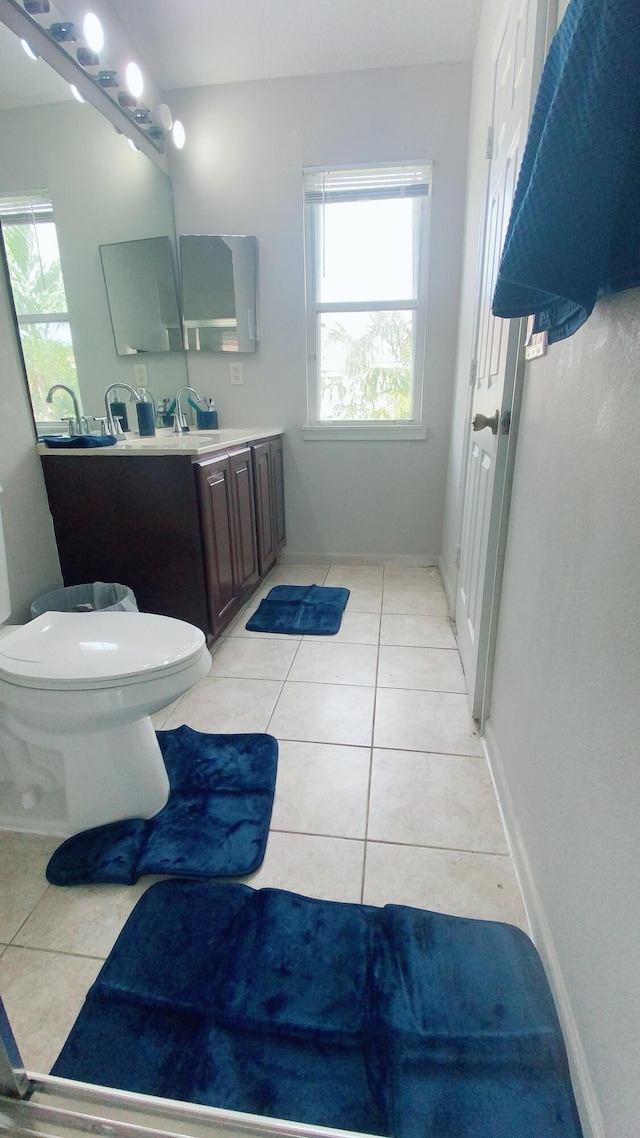 bathroom with vanity, tile patterned flooring, toilet, and baseboards