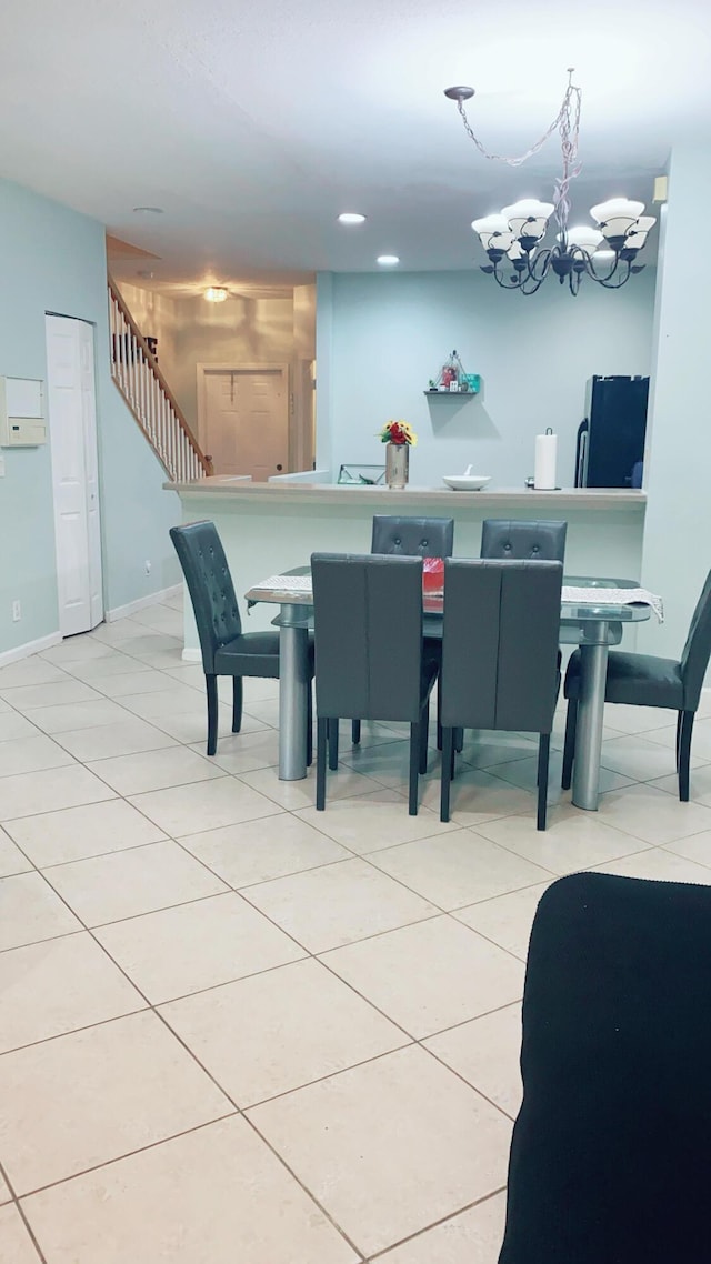 dining area featuring light tile patterned flooring and an inviting chandelier