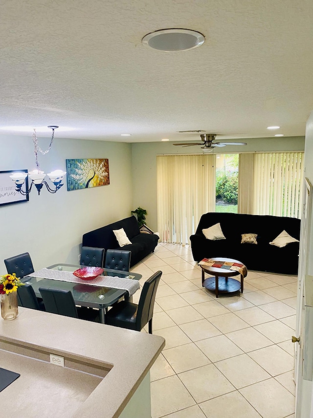 living room with a textured ceiling, ceiling fan, and light tile patterned floors