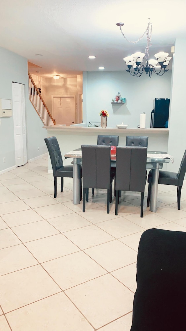 dining space featuring a chandelier, stairs, baseboards, and light tile patterned floors