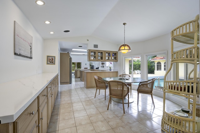 tiled dining space featuring vaulted ceiling and sink