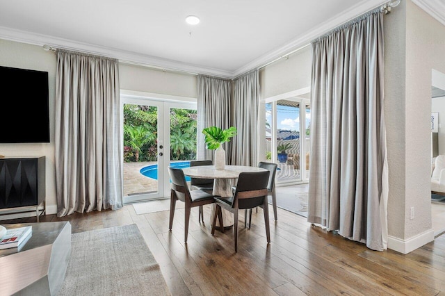 dining room featuring hardwood / wood-style flooring, ornamental molding, and french doors