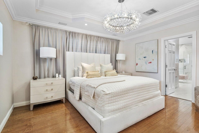 bedroom featuring a notable chandelier, ensuite bath, wood-type flooring, and ornamental molding