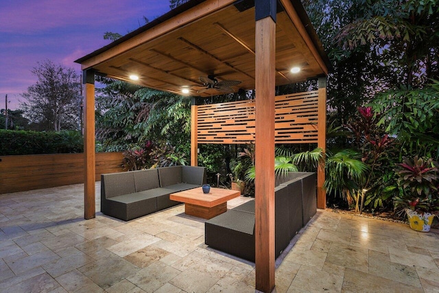 patio terrace at dusk with an outdoor living space and ceiling fan