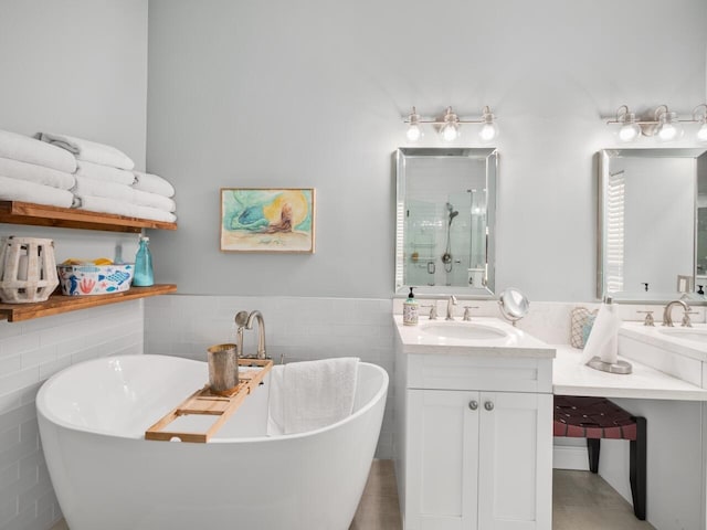 bathroom featuring separate shower and tub, vanity, and tile walls