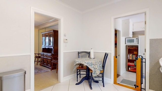 dining area featuring tile patterned flooring, baseboards, and crown molding