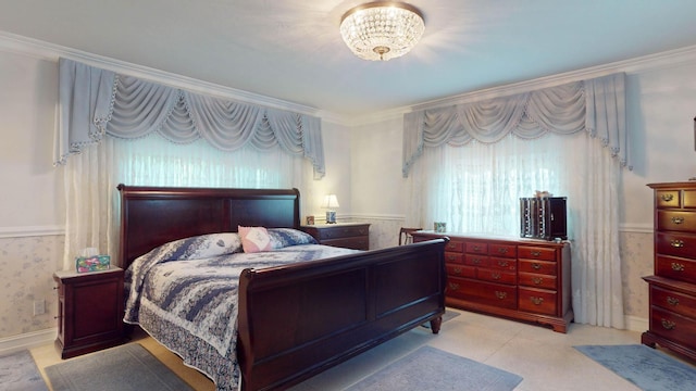 bedroom with crown molding, wainscoting, and wallpapered walls