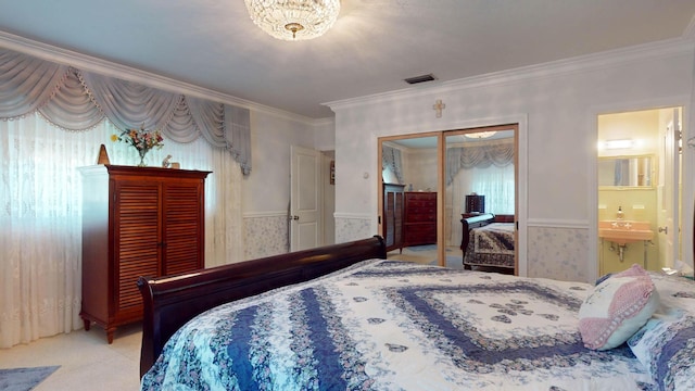 carpeted bedroom featuring wainscoting, crown molding, visible vents, and wallpapered walls