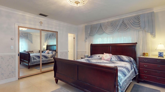 bedroom featuring visible vents, a closet, wainscoting, wallpapered walls, and crown molding