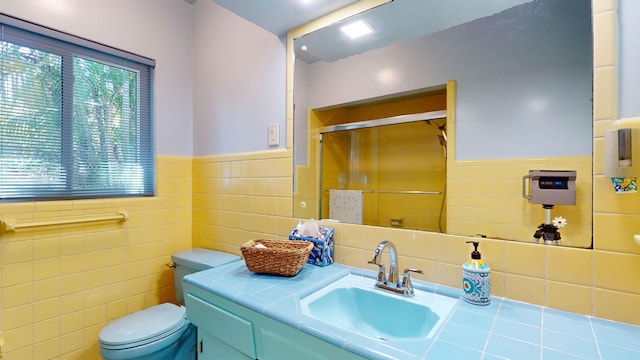 bathroom featuring a wainscoted wall, a stall shower, vanity, and toilet