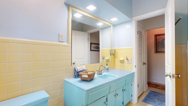 bathroom featuring tile patterned floors, tile walls, toilet, and vanity