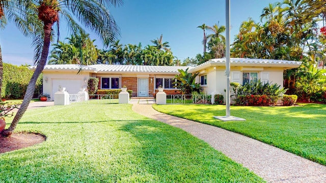 ranch-style house featuring an attached garage, fence, a front lawn, and stucco siding