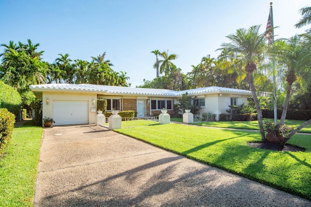 single story home with a front yard, driveway, an attached garage, and stucco siding