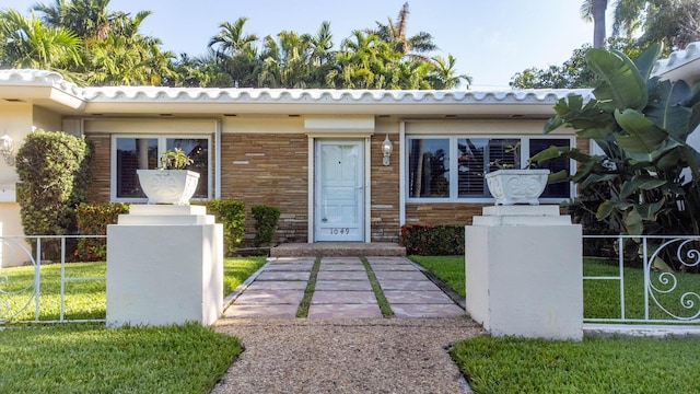 view of front of home featuring stone siding and fence