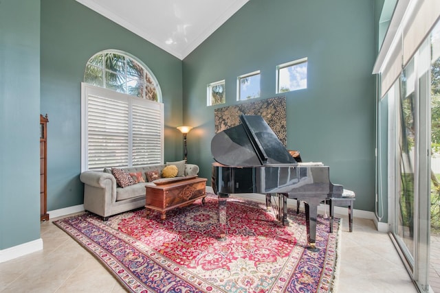 sitting room with crown molding, light tile patterned floors, and high vaulted ceiling