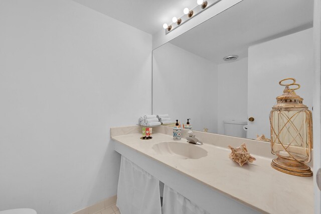 bathroom featuring toilet, tile patterned floors, and sink