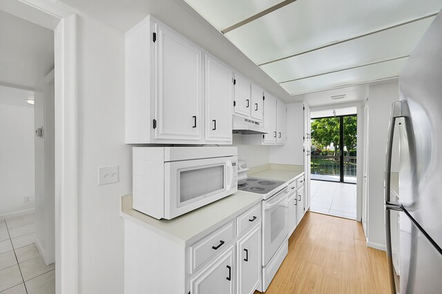 kitchen featuring light tile patterned floors, white cabinetry, and white appliances