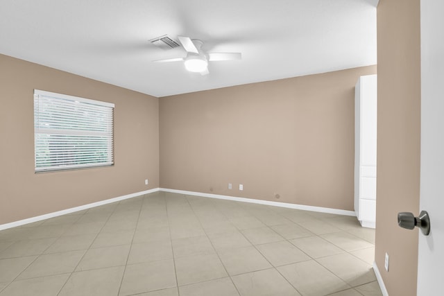 tiled spare room with ceiling fan