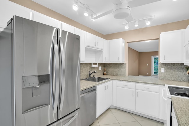 kitchen featuring sink, white cabinetry, light tile patterned floors, stainless steel appliances, and backsplash