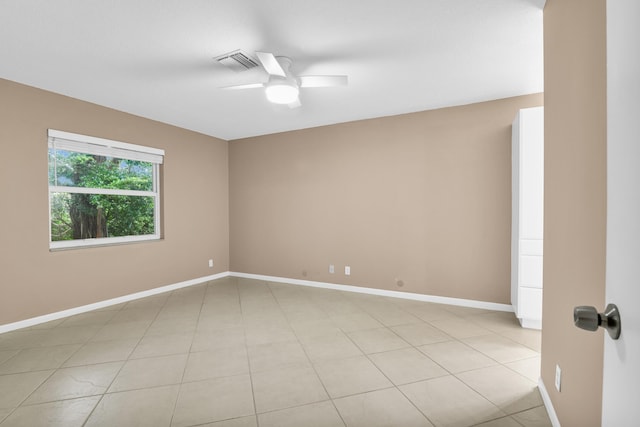 tiled empty room featuring ceiling fan