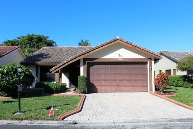 ranch-style house with a lawn and a garage