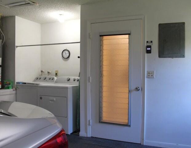 laundry area featuring independent washer and dryer, electric panel, and a textured ceiling