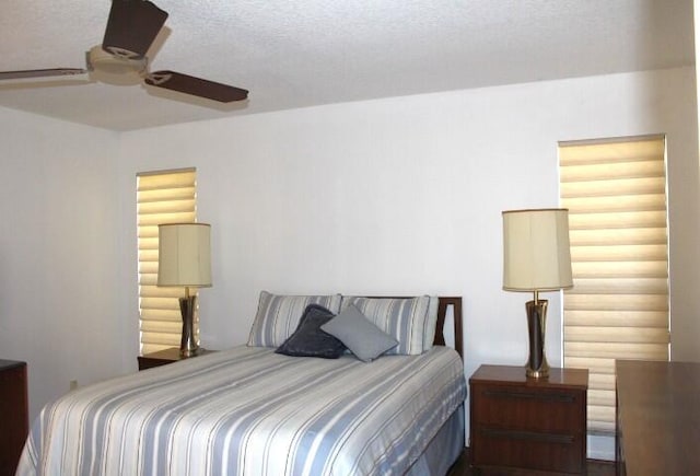 bedroom with ceiling fan and a textured ceiling