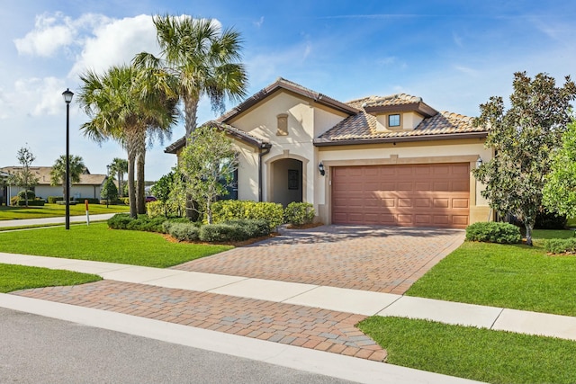 mediterranean / spanish-style home featuring a garage, a tile roof, a front yard, and stucco siding