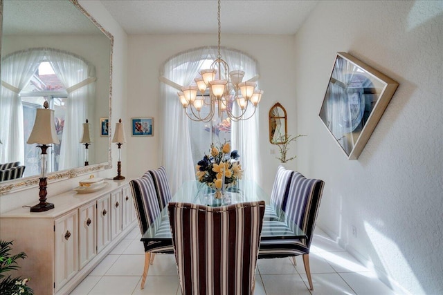 tiled dining space with an inviting chandelier and a textured ceiling