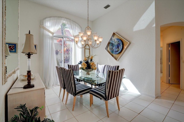 tiled dining room with a chandelier and a textured ceiling